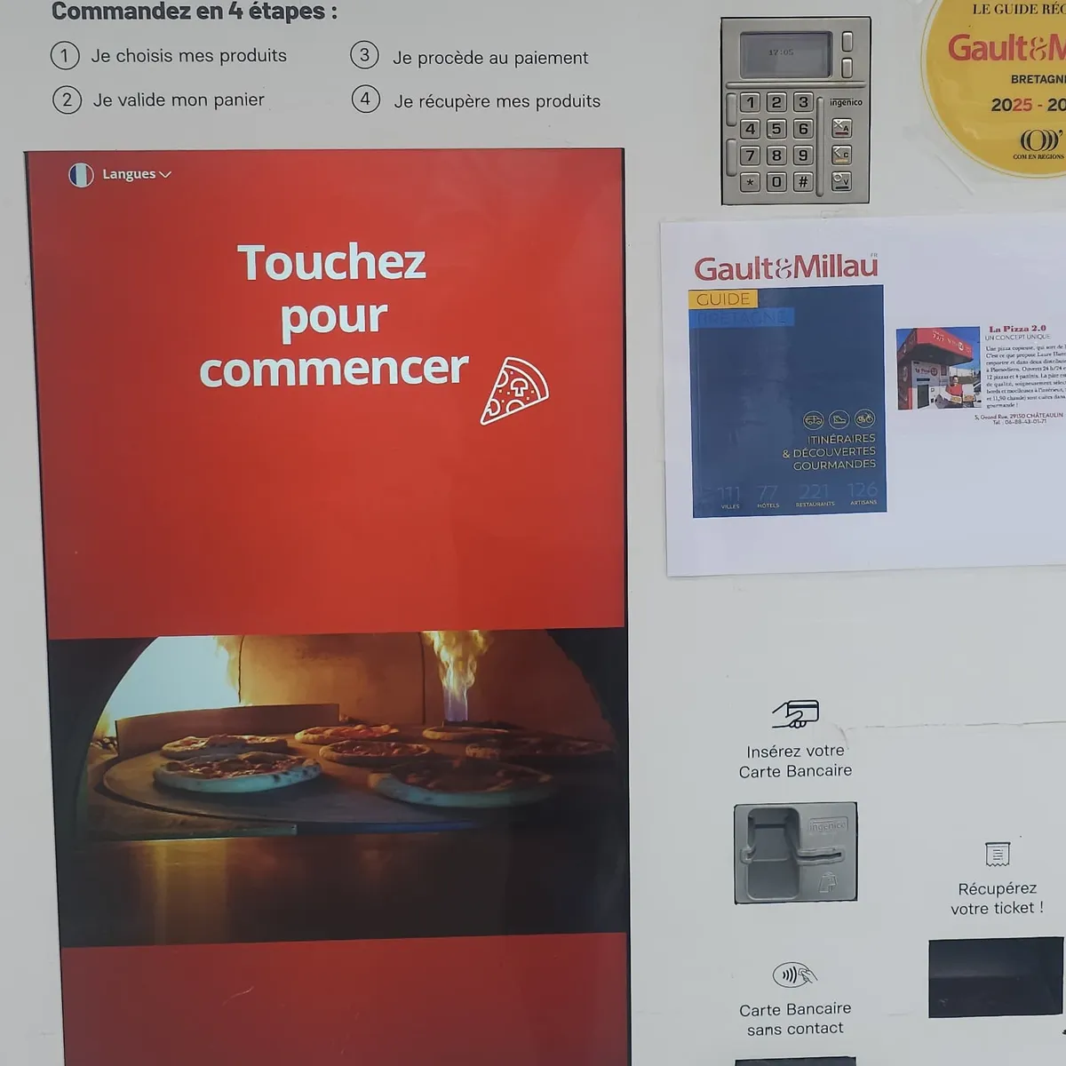 L'écran tactile du distributeur La Pizza 2.0, « Touchez pour commencer », à côté de l'autocollant Gault&Millau